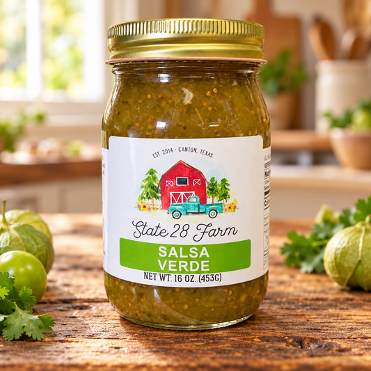 State 28 Farm Salsa Verde 16 oz jar on a rustic wooden table with tomatillos and cilantro